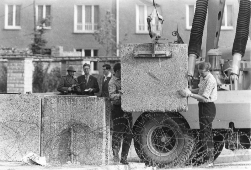 Mauerbau Berlin.- Mauerbau, Aufstellen von Betonblöcken mit einem Kran hinter Stacheldraht