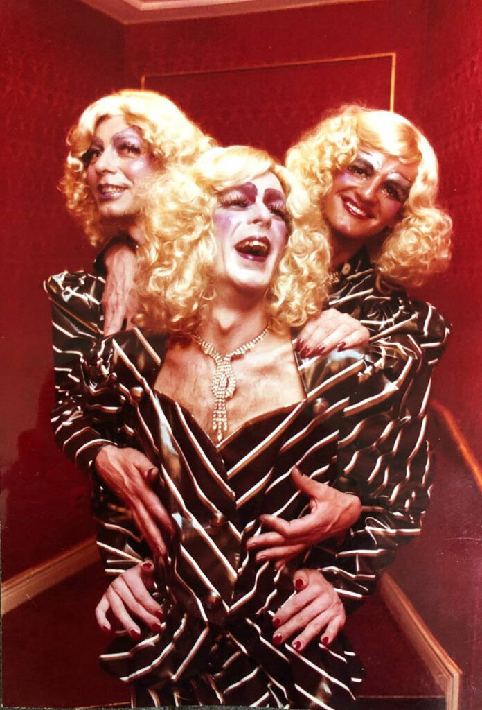 Drei Travestiekünstler in einheitlichem Kostüm, eng zusammen