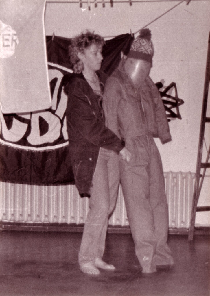 Eine Frau steht auf der Bühne des Hibarés und hält eine lebensgroße Puppe im Arm, ein Comedy-Sketch vermutlich