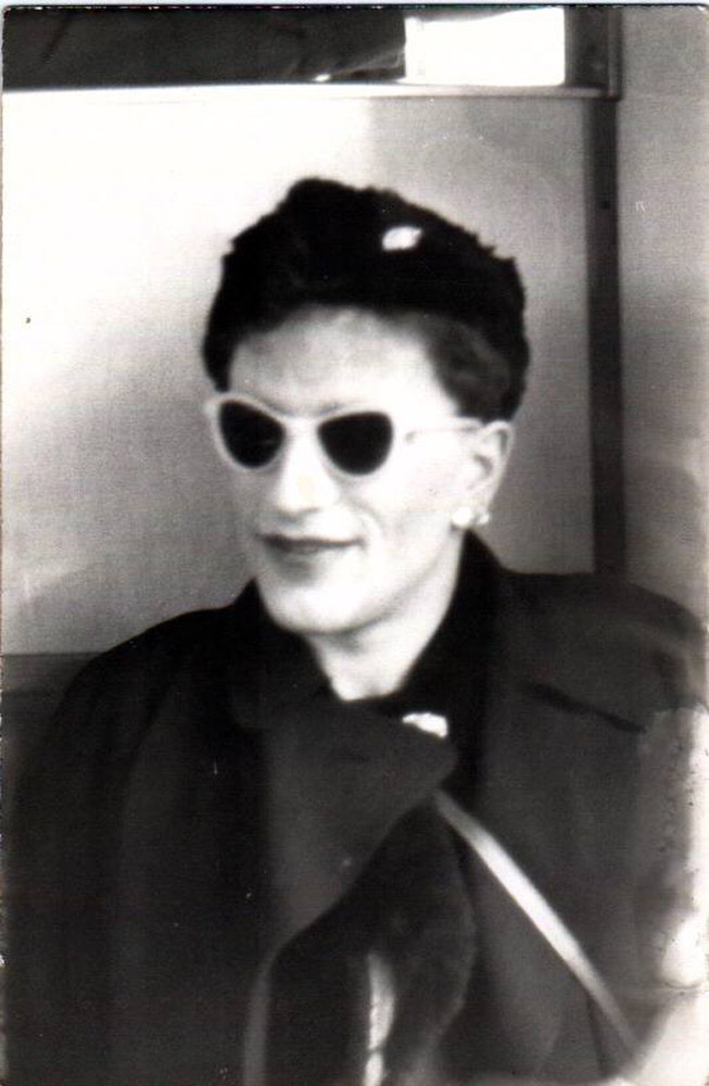 Mann, lachend im Kleid mit Hut auf dem Kopf