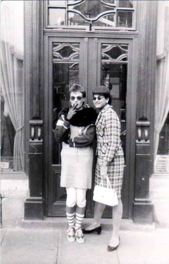 Zwei Personen im Fummel vor einem Teehaus, mit Zigarette und Handtasche, 1983